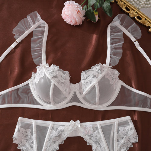 Floral embroidered bridal lingerie set with garter belt and ruffle straps, white sheer lace intimate apparel for wedding night.