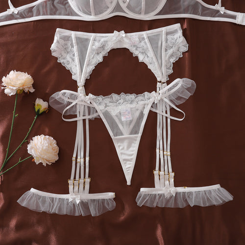 Floral embroidered bridal lingerie set with garter belt and ruffle straps, white sheer lace intimate apparel for wedding night.
