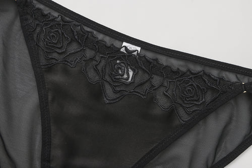 KissKismet black satin corset lingerie set. Features a lace-up longline bustier with French rose embroidery and a matching sheer mesh panty, perfect for dark romance styling or lingerie-as-outerwear looks.
