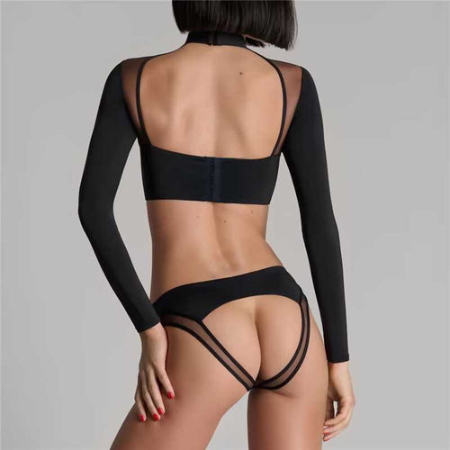Back view of a model showcasing the open-back design of the long-sleeve top and the cheeky cut-out strappy details of the black panty.