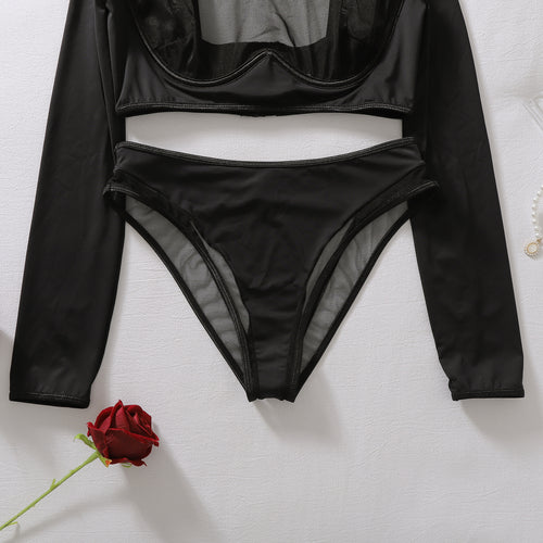 Close-up flat lay of the black shaping panty, showing the sheer mesh paneling and distinct structural lines.