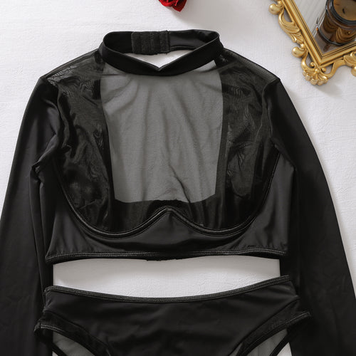 Close-up flat lay of the black long-sleeve top, detailing the high neckline and sheer mesh chest panel.