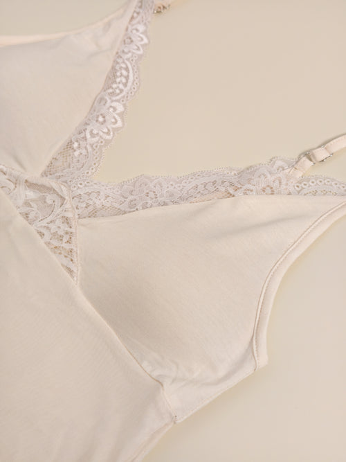 Close-up flat lay detailing the built-in bra pads and intricate lace V-neckline of the modal nightgown.