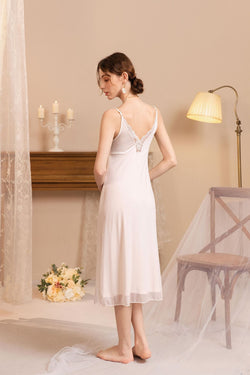 Side view of a model wearing a flowing modal lace nightgown, highlighting the elegant drape and delicate back straps.   