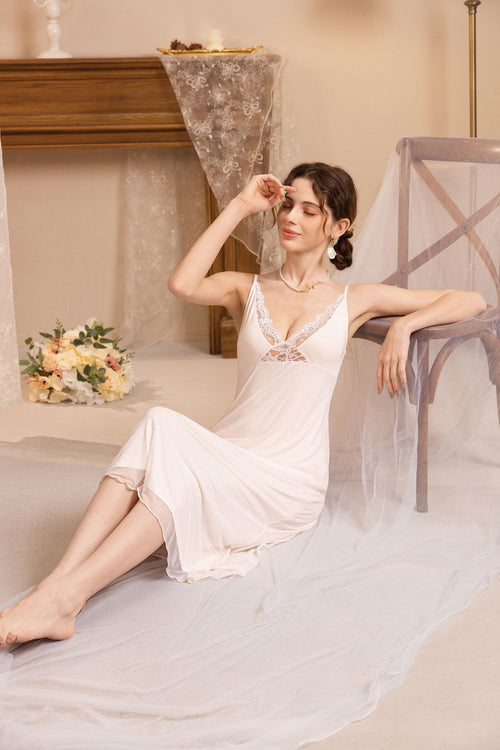 A model sitting gracefully on the floor wearing a soft pink modal fairy nightgown featuring delicate lace trim.