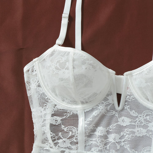 Close-up flat lay of the white lace underwire cups, detailing the center cut-out and delicate floral embroidery.   