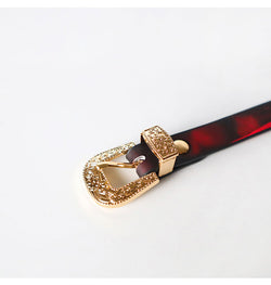 Extreme close-up of the premium gold buckle and adjustable leather strap.