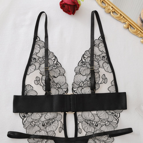 Close-up flat lay showing the adjustable shoulder straps and plunge neckline of the bodysuit.
