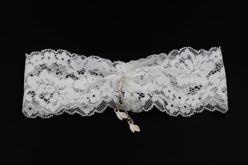 Flat lay product shot on a clean black background, focusing on the white lace structure and the complete chain fringe tassels.