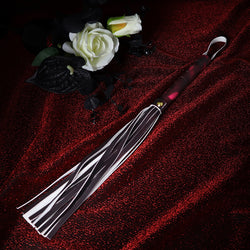 Flat lay view of color-changing leather tassel whip