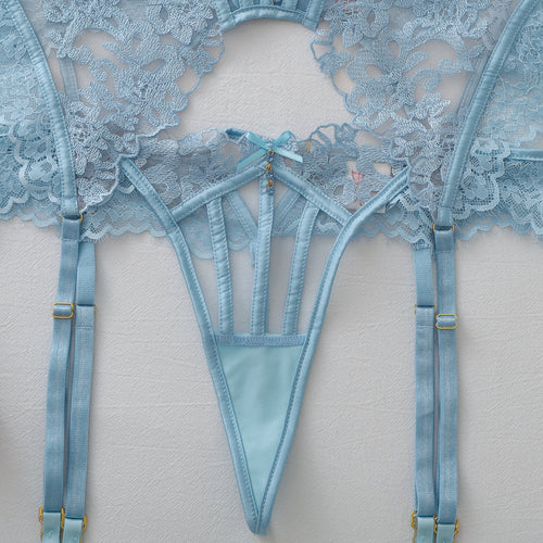 Close-up flat lay detailing the strappy thong and adjustable garter straps of the lingerie set.