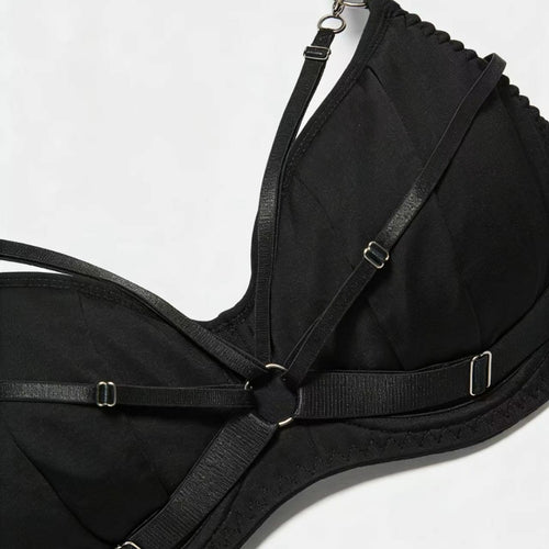 Close-up view focusing on the intricate front strapping and striking central metallic O-ring hardware of the KissKismet bra.