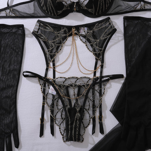 Flat lay view of the KissKismet matching strappy garter belt, cheeky thong, and sleek black opera gloves.