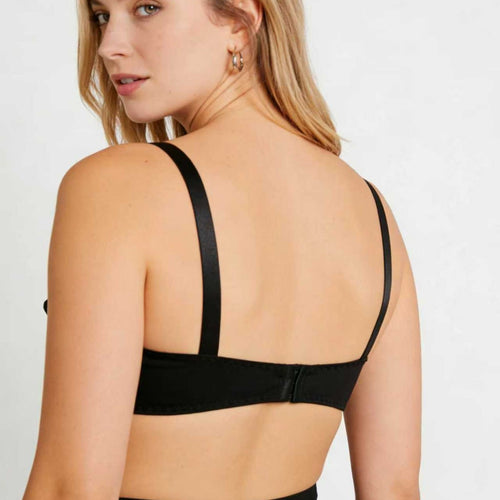 Back view of a model showcasing the secure hook-and-eye closure and wide adjustable shoulder straps of the KissKismet black bra.