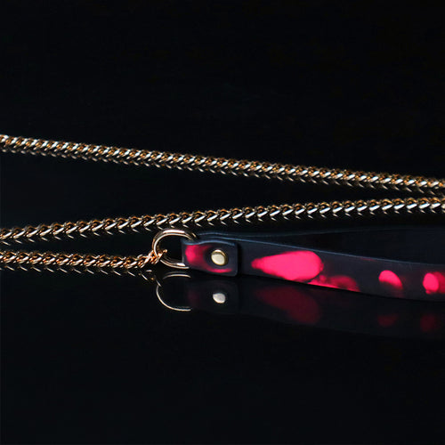 Detail shot of the thermal color-changing leather leash handle connected to a gold chain.