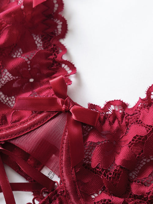 Detailed close-up flat lay of the daring corset-style criss-cross lace-up front on the KissKismet red teddy.
