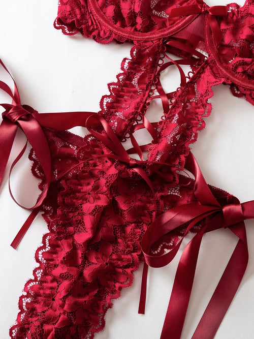 Detailed close-up showing the seductive side-tie ribbon bows and delicate floral lace of the KissKismet bodysuit.