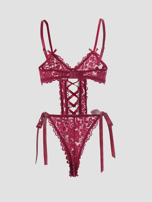 Full flat lay display of the KissKismet crimson lace-up garter bodysuit, emphasizing its structural and romantic design.