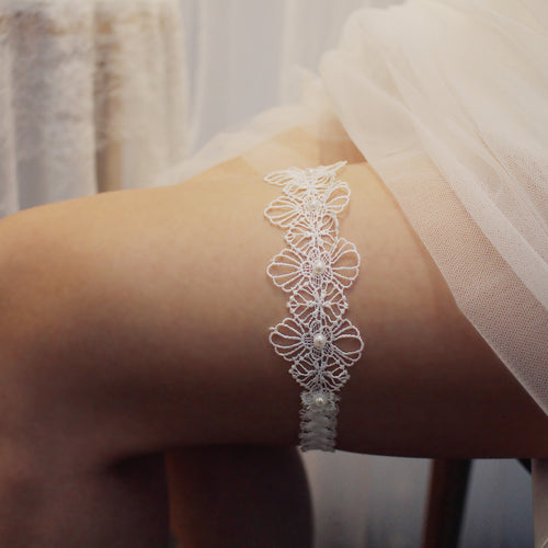 Side view of a bride's leg wearing an elegant white stretch lace elastic garter