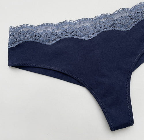 Angled flat lay view detailing the side construction and lace integration of the navy thong.