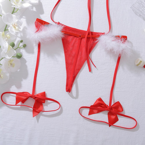 Close-up flat lay of the red thong bottom with white faux fur trim and attached strappy thigh garters.