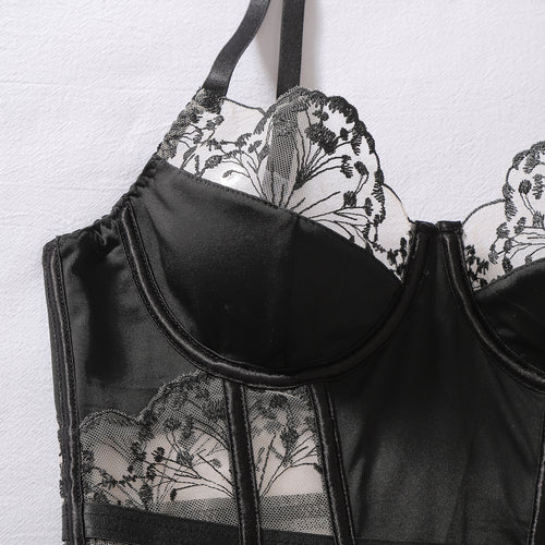Macro flat lay focusing on the delicate floral embroidered underwire cups and thin shoulder straps.