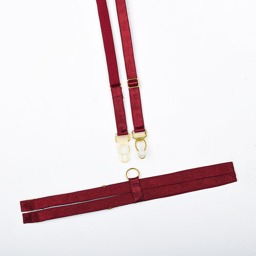 Flat lay presentation of the fully adjustable elastic leg harnesses included in the KissKismet crimson desire lingerie set.