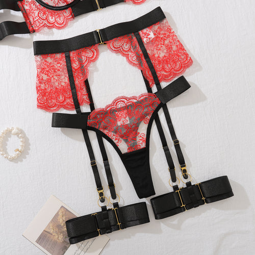 Flat lay view of the KissKismet high-waisted crimson lace garter belt with bold black adjustable leg rings and matching thong.