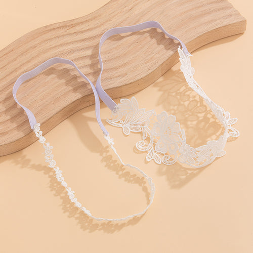 Flat lay detail of the white floral lace thigh garter, showing the flexible elastic back band for a comfortable fit.