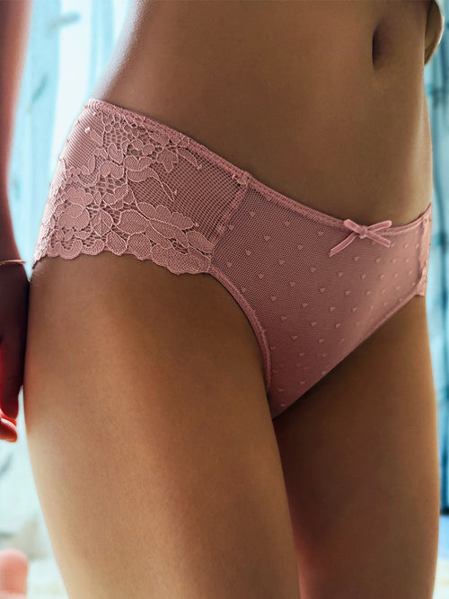 Front lifestyle shot of a model wearing the KissKismet dusty pink dotted mesh and floral lace cheeky panty.