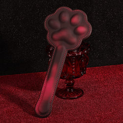 Elegant display of the KissKismet premium leather cat paw paddle, showcasing its sleek handle and playful silhouette.