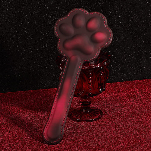Elegant display of the KissKismet premium leather cat paw paddle, showcasing its sleek handle and playful silhouette.