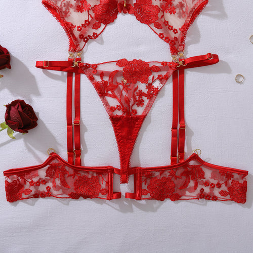 Close-up flat lay detail of the KissKismet red rose embroidered waist-cinching garter belt and matching sheer mesh thong.