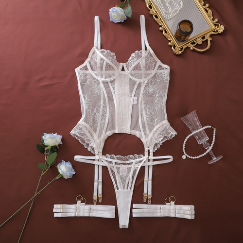 Flat lay of full white embroidered corset and garter set