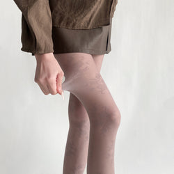 Close-up side view demonstrating the high-stretch spandex blend and soft-focus sheer finish of the KissKismet mauve floral pantyhose.