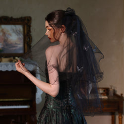 Side view of a model wearing the midnight flutter black veil with 3D butterfly appliques and curled edges.