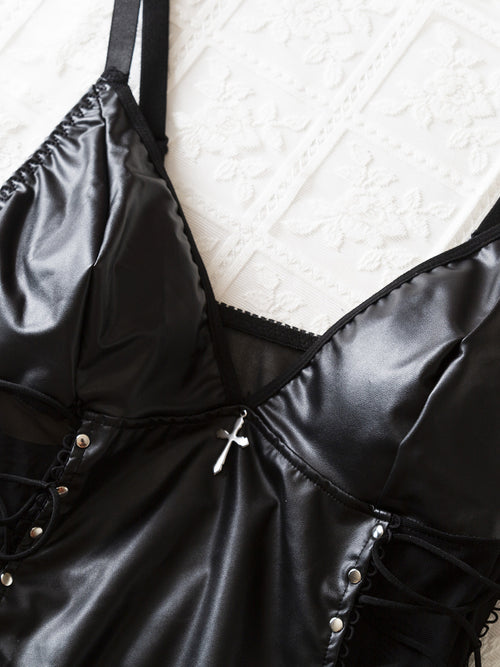 Close-up hanging view focusing on the deep V-neckline and structural bust seams of the black faux leather lingerie.