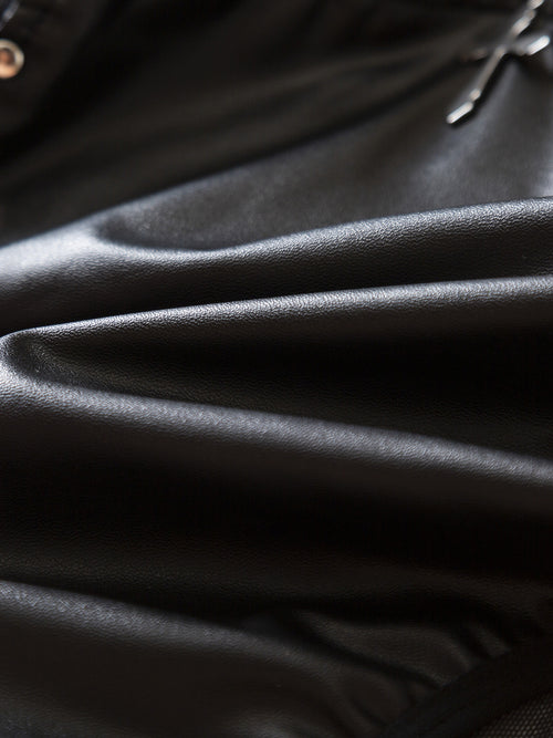 Extreme macro shot highlighting the smooth, high-stretch wet-look texture of the premium faux leather fabric.