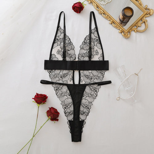 Full flat lay view of the sheer black lace teddy surrounded by romantic red roses.