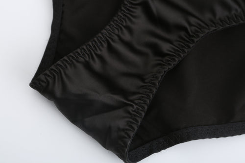 Macro detail shot of the KissKismet black satin panty, showcasing the smooth, luxurious fabric texture and durable stitching.