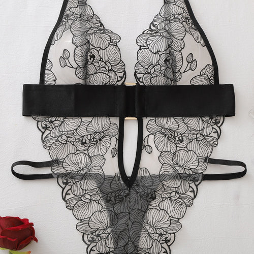 Flat lay showing the full front of the sheer floral embroidered bodysuit with cutout details.