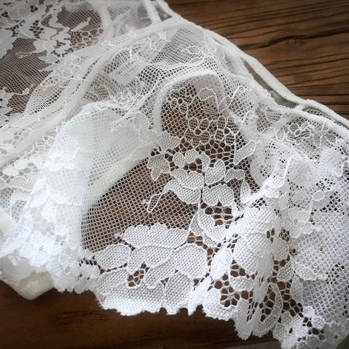 Close-up detail of the delicate white floral lace pattern and premium scalloped hem on the KissKismet intimate wear.