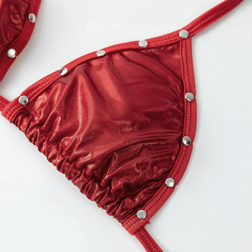 Close-up of the red metallic bikini top cup featuring silver stud embellishments