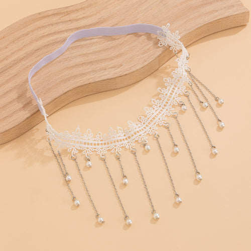 Flat lay detail of the white lace thigh garter, revealing the flexible elastic back band on a beige surface.