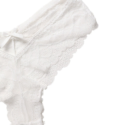 Close-up flat lay detail of the playful V-shaped strappy cut-out and dainty satin bow on the back of the white lace thong.